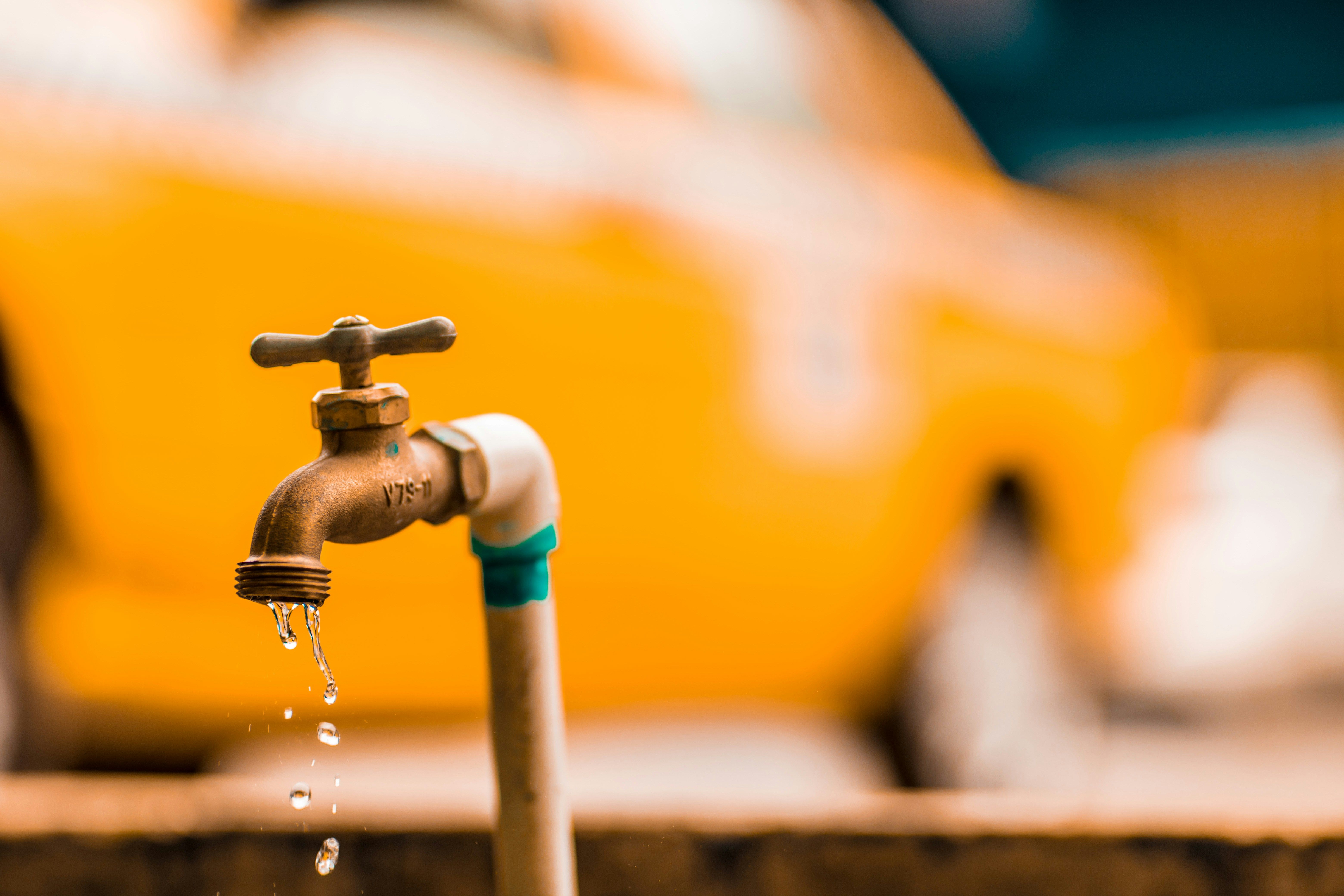 Experienced plumbing service background showing a leaking water spigot